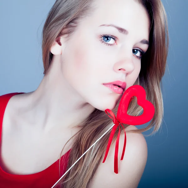 Schöne junge Blondine mit rotem Herz — Stockfoto