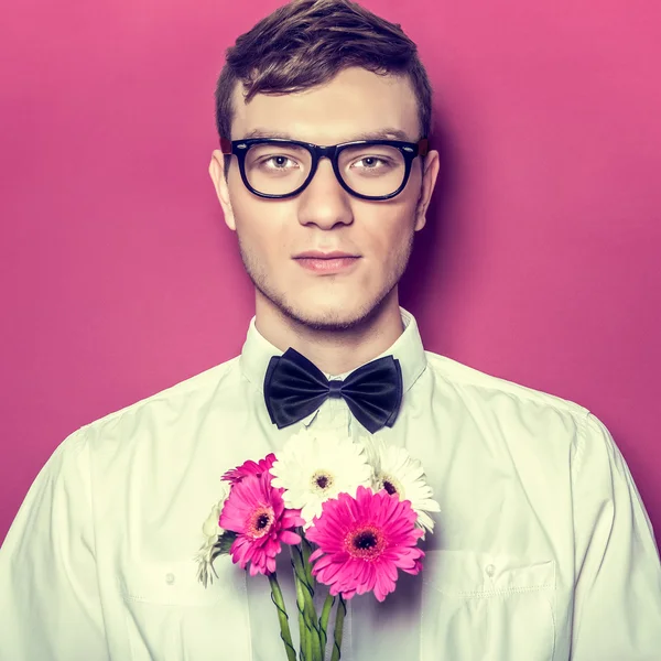 Jovem homem bonito com flores — Fotografia de Stock