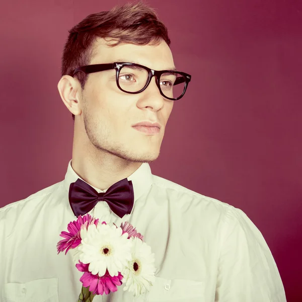 Junger schöner Mann mit Blumen — Stockfoto