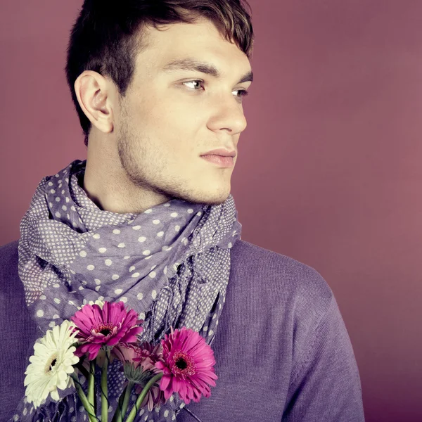 Junger schöner Mann mit Blumen — Stockfoto