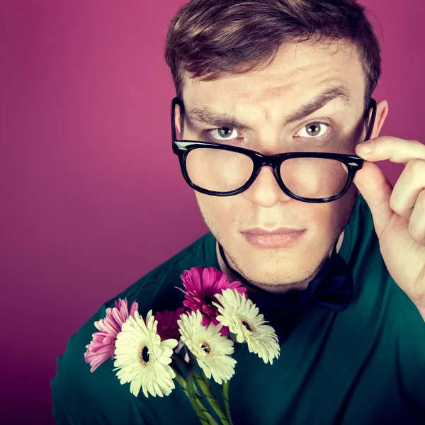 Çiçek taşıyan büyük gözlüklü bir adam portresi — Stok fotoğraf