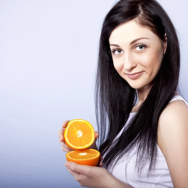 Gelukkig meisje met oranje in haar handen — Stockfoto