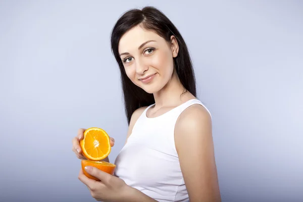 Joven chica feliz con naranja en sus manos —  Fotos de Stock