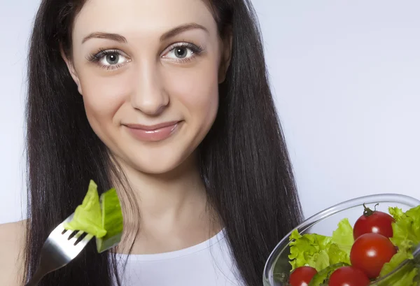 Крупный план красивой молодой женщины, которая ест салат — стоковое фото