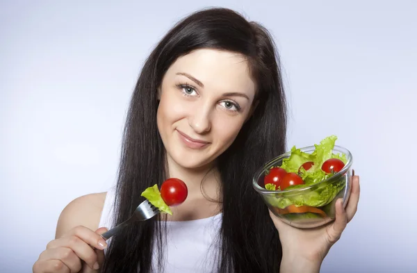 Портрет красивой молодой девушки, которая ест овощной салат — стоковое фото