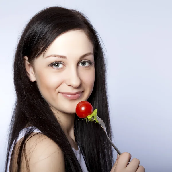 Portret van een mooie vrouw met een tomaat — Stockfoto
