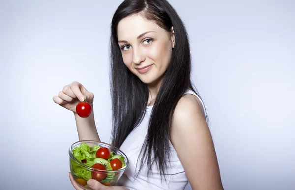 Портрет красивой молодой девушки, которая ест овощной салат — стоковое фото