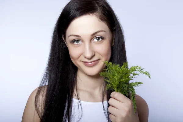 Portret mooie jonge vrouw die lacht bedrijf groene dill — Stockfoto