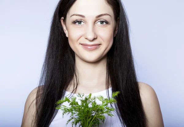 Portrait beautiful young woman smiling holding green dill — Stock Photo, Image
