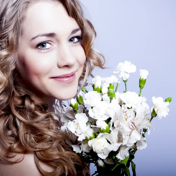 Jovem feliz sorrindo mulher com flores — Fotografia de Stock