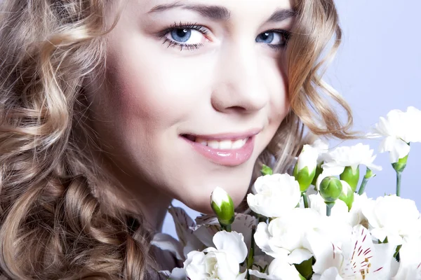 幸せな若い笑顔の女性の花を持つ — ストック写真