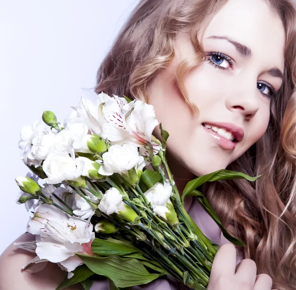 Glückliche junge lächelnde Frau mit Blumen — Stockfoto