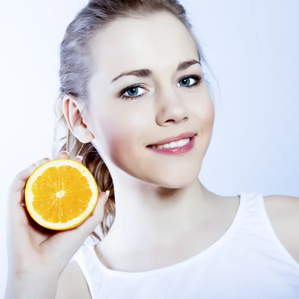 Jovem menina feliz com laranja em suas mãos — Fotografia de Stock