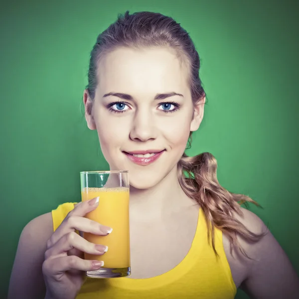 Glad flicka med apelsinjuice i hennes händer — Stockfoto