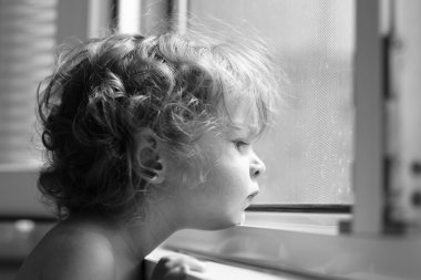 Child looking into window clipart