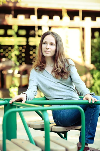 stock image Young smiling woman on carousel