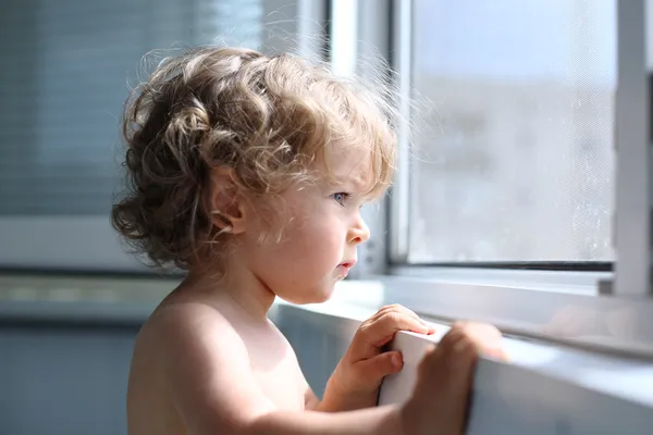 Child looking into window — Stock Photo, Image
