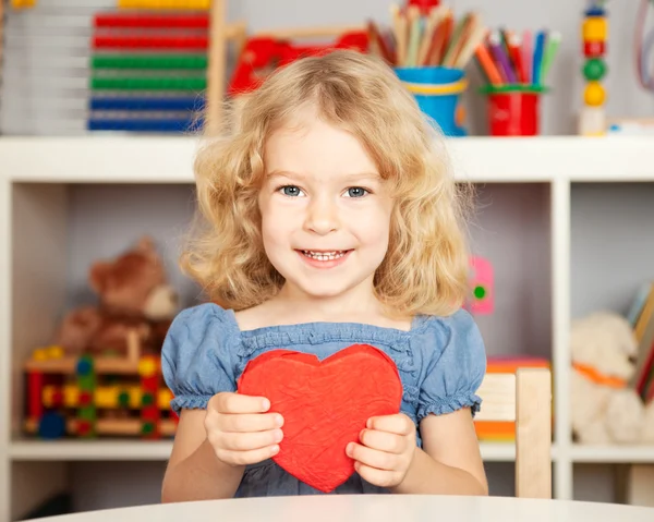 Счастливый ребенок с бумажным сердцем — стоковое фото