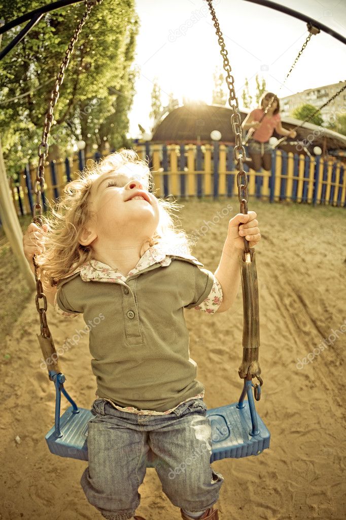 Child on swing in summer