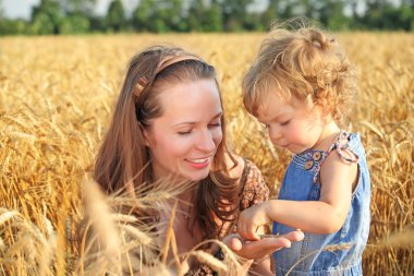 Woman with child in field clipart