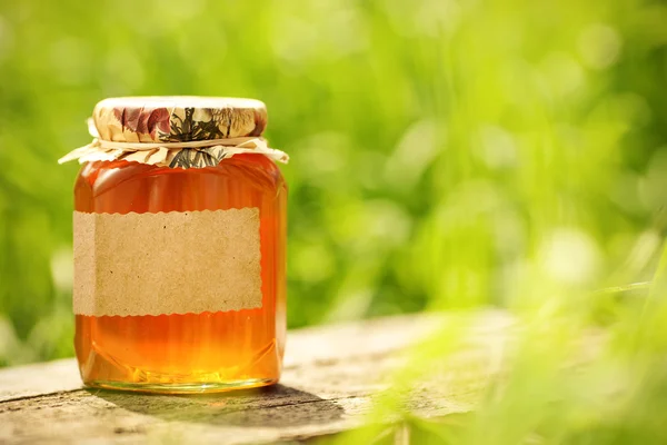 Цветочный мед с пустой этикеткой в стеклянной банке — стоковое фото
