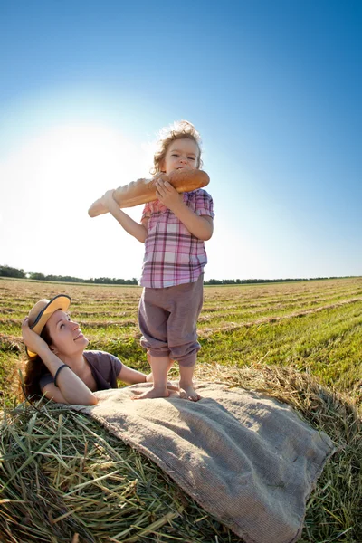 Szczęśliwą kobietą i dzieckiem w polu pszenicy — Zdjęcie stockowe