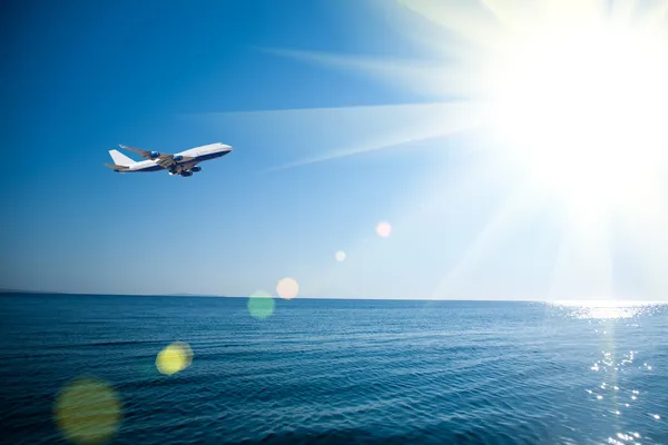 Airplane flying over the sea — Stock Photo, Image