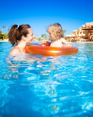 Child with mother in swimming pool clipart