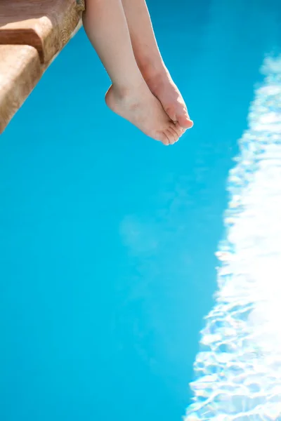 Kinderfüße gegen blaues Schwimmbad — Stockfoto