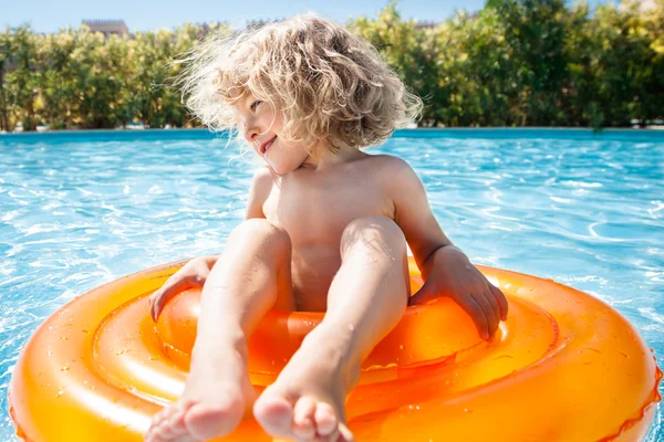 Criança feliz brincando na piscina — Fotografia de Stock