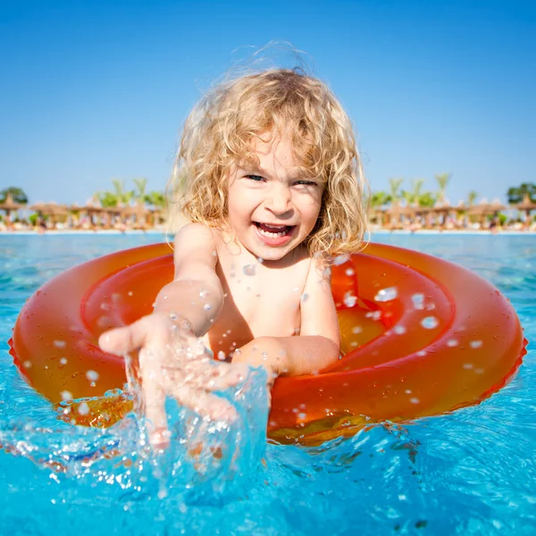 Niño feliz jugando en agua azul — Foto de Stock