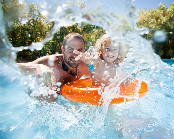 Kind met vader in zwembad Stockfoto