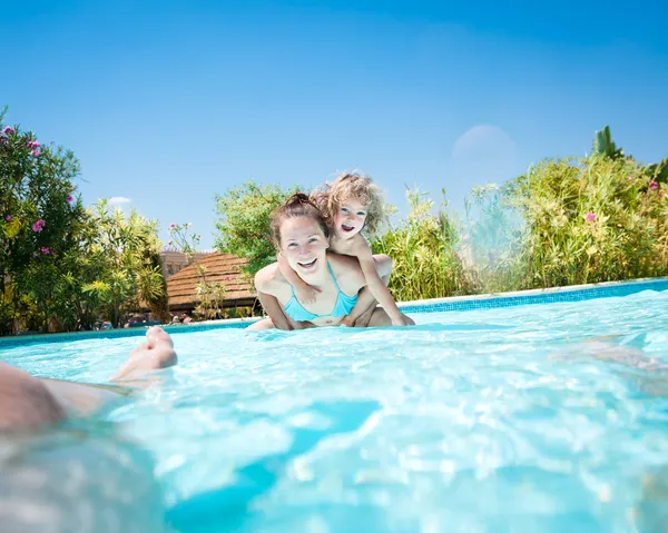 Glad familj leker i poolen — Stockfoto