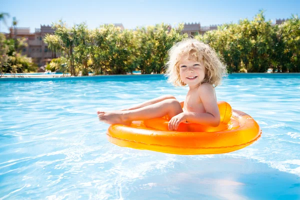 Счастливый ребенок плавает в бассейне — стоковое фото