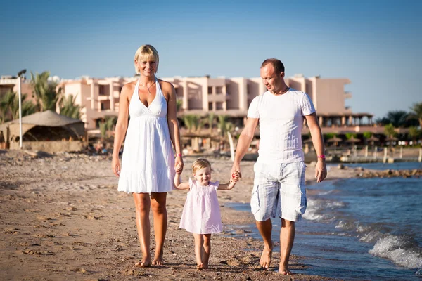 Lycklig familj promenader på stranden — Stockfoto