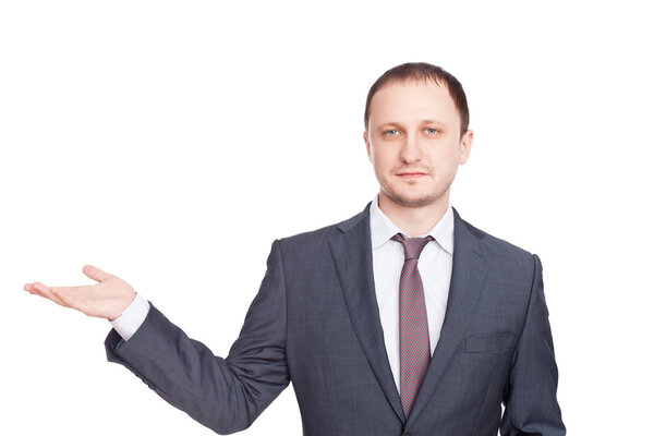 Young businessman in a suit presenting something isolated on white background