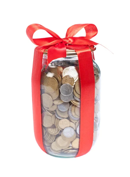 Münzen im Glas mit roter Schleife auf weißem Hintergrund — Stockfoto