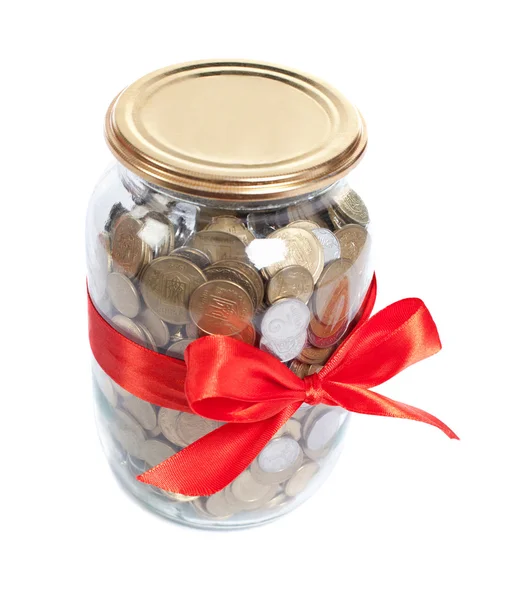 Coins in the jar with red ribbon on white background — Stock Photo, Image