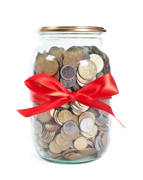 Coins in the jar with red ribbon on white background — Stock Photo, Image