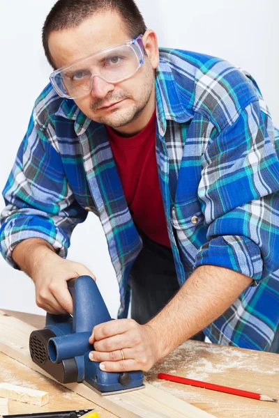 Carpinteiro ou marceneiro que trabalha com plaina elétrica — Fotografia de Stock