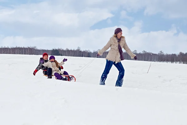 儿童雪橇骑马-帮助他们的母亲 — 图库照片