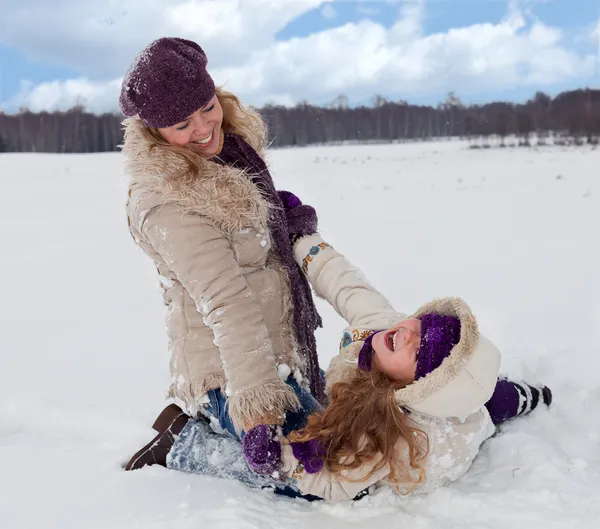 Kvinna och liten flicka ha kul i snön — Stockfoto
