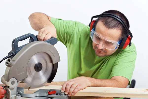 Carpenter cutting wooden plank — Stock Photo, Image