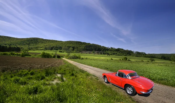 Červené auto na venkově — Stock fotografie