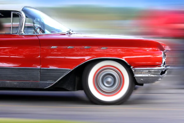 Gyorsan mozgó klasszikus piros autó — Stock Fotó