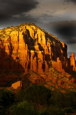 Grey clouds over red rock mountains clipart