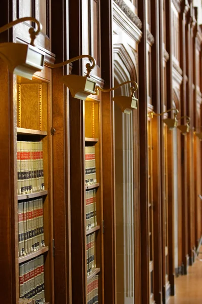 Lagböcker i hylla i biblioteket — Stockfoto