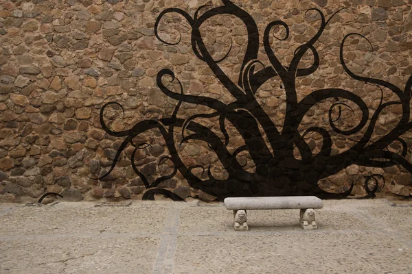 stock image Old stone wall with bench and graffiti