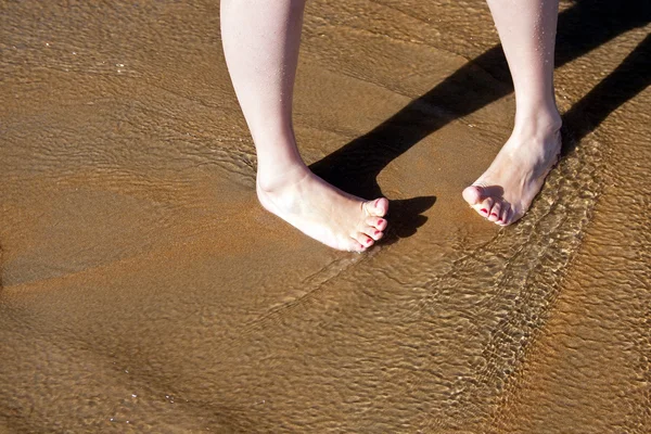 Barefoot female feet in surf on — Stock Photo, Image