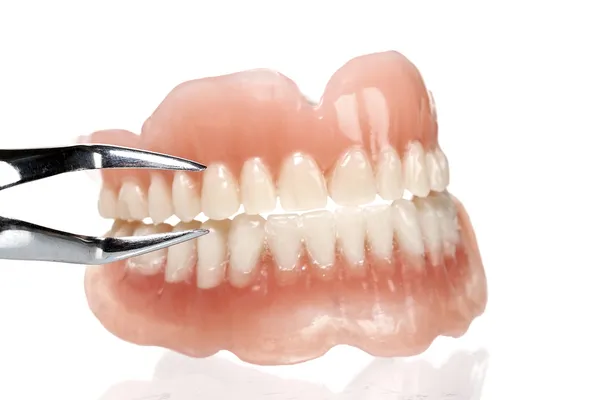 ACRYLIC DENTURE- FULL FRONT SET with a tool — Stock Photo, Image